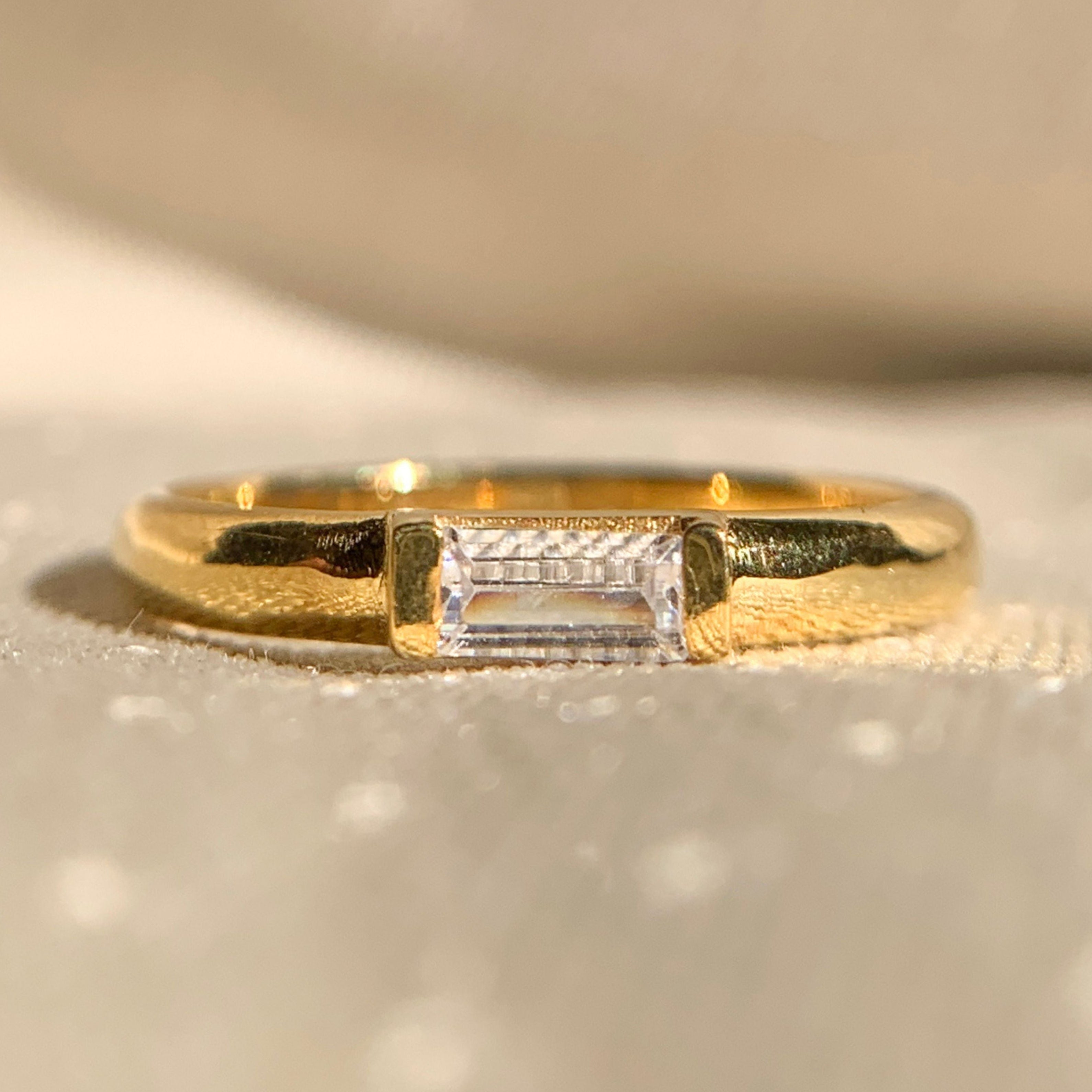 East-West solitaire baguette diamond wedding band in sleek gold setting